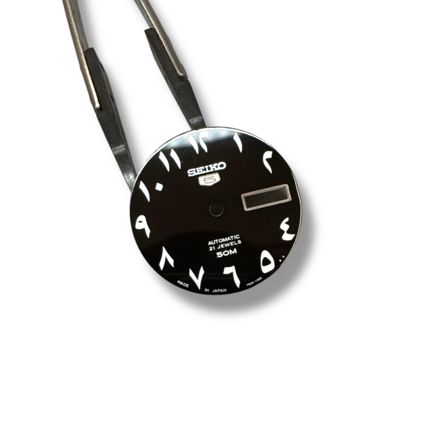 A black Seiko watch dial with Arabic numerals and a date display.