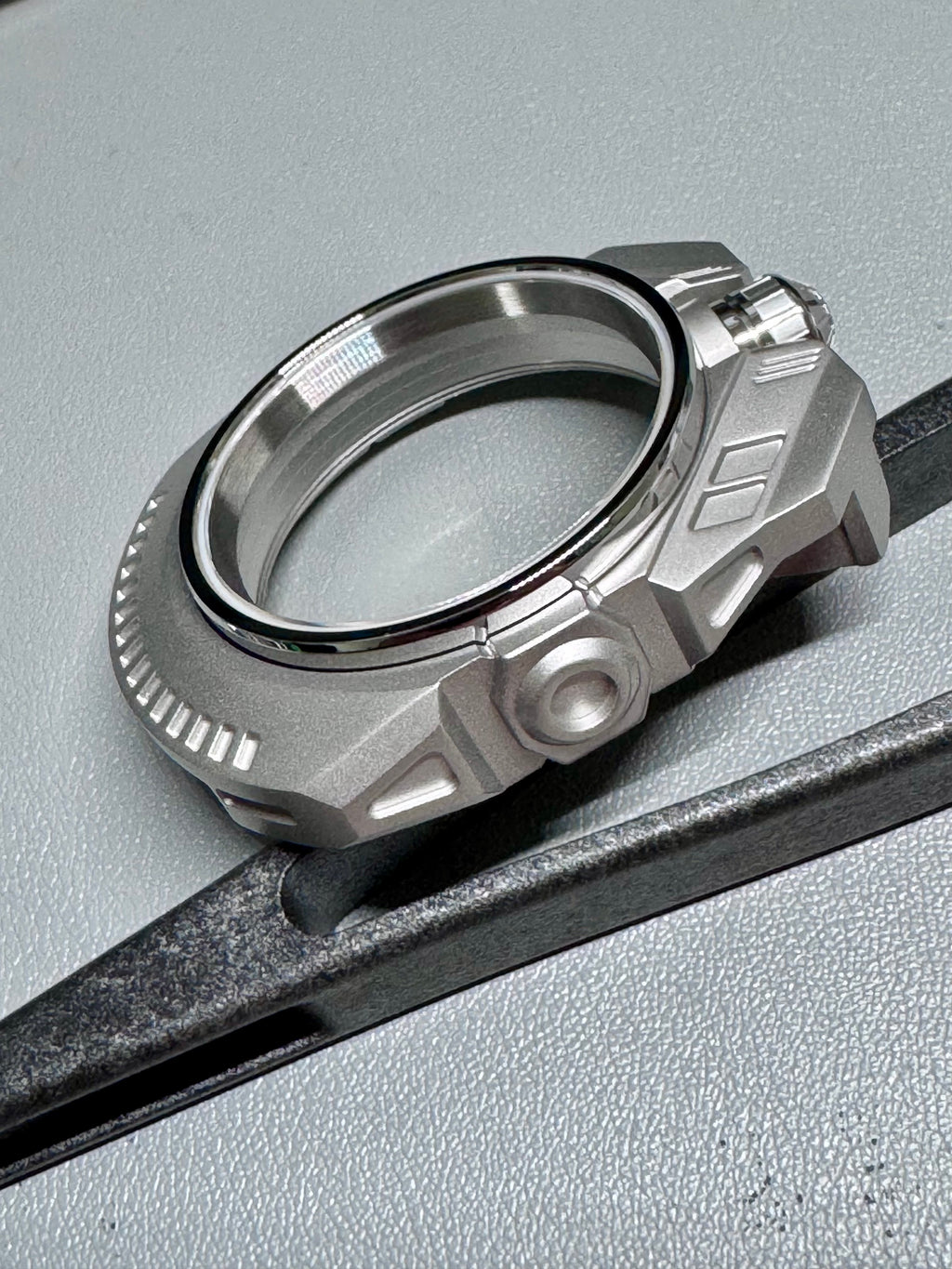 Silver watch part on a gray surface