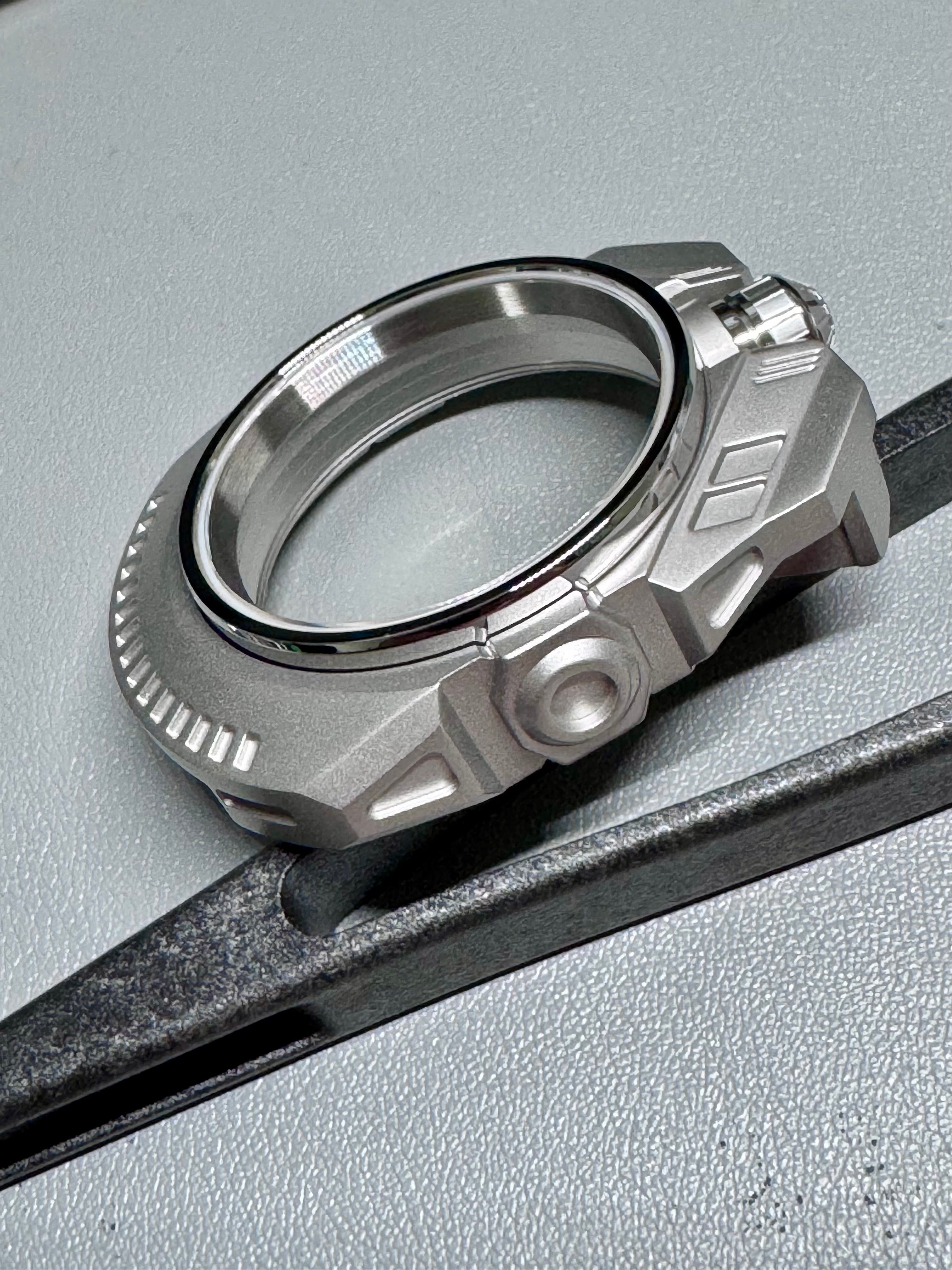 Silver watch part on a gray surface