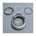 Mechanical watch components including a metal ring, glass cover, and rubber gasket on a gray background.